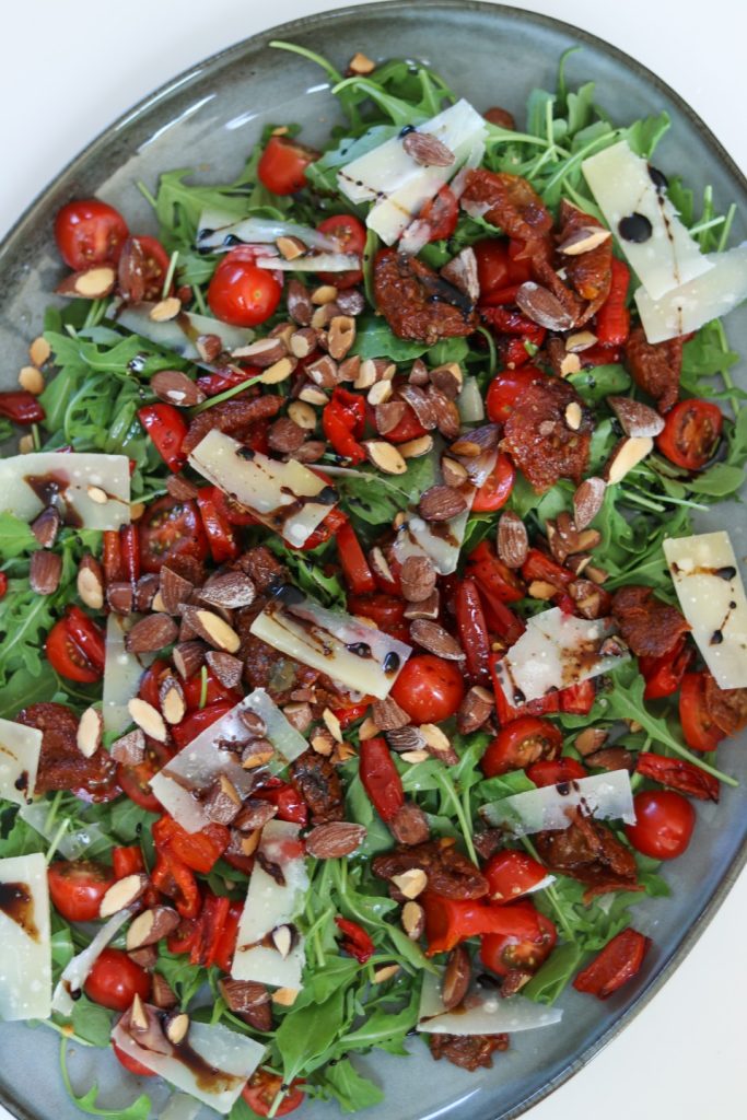 Rucola med bagte peberfrugter og saltmandler