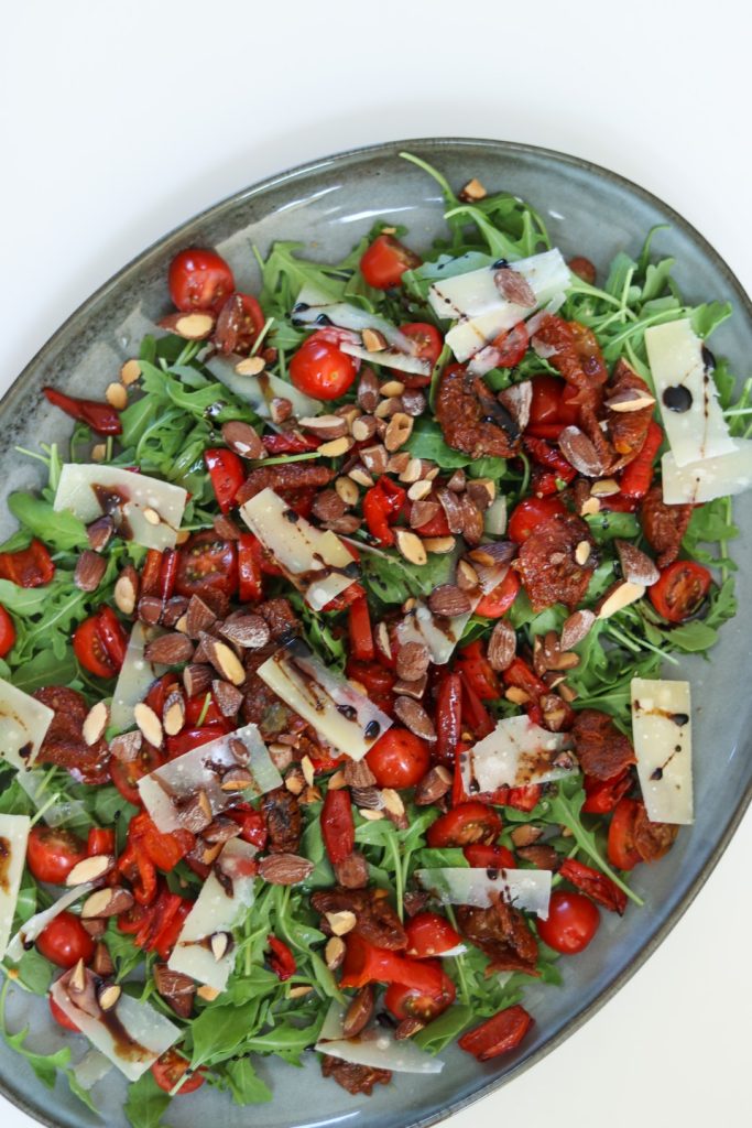 Rucola med bagte peberfrugter og saltmandler